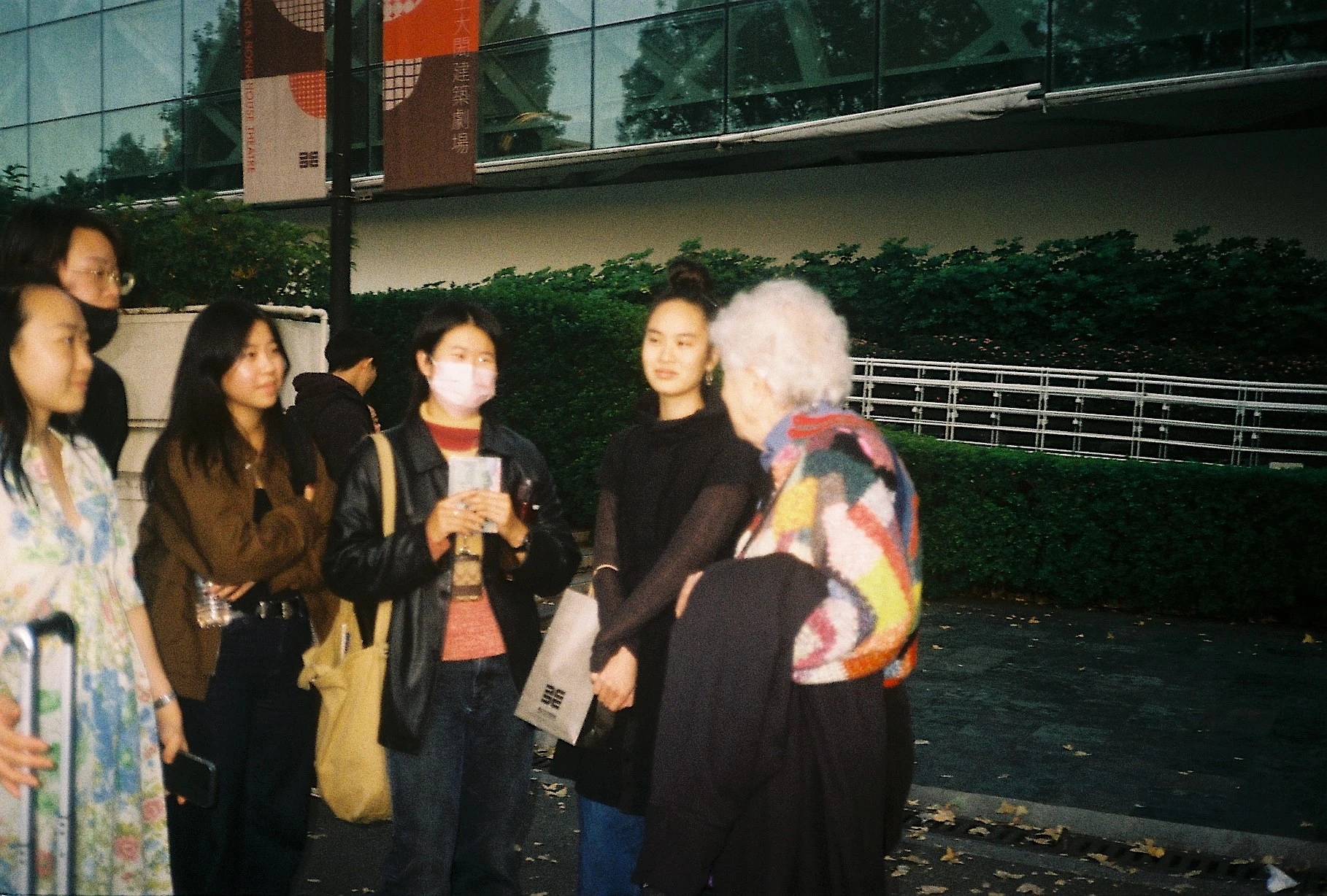 薩米亞．哈拉比在台北市立美術館館外與一群年輕人談話。2023年11月19日。-圖片